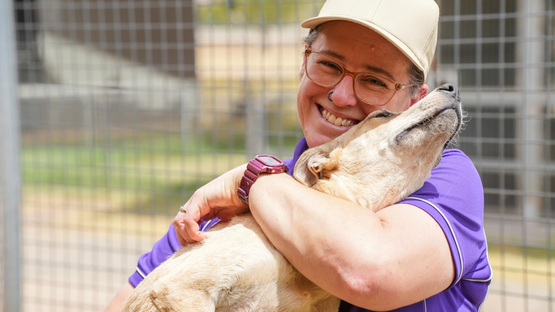 An Animal Shelter team member holding a puppy